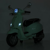 Мятный детский скутер Vespa M 6288EL-15 со включенными фарами в темноте