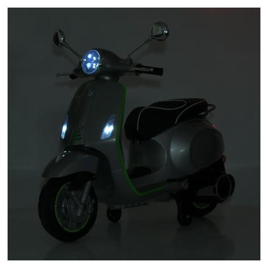 Передня фара сірого скутера Vespa у ввімкненому стані вночі