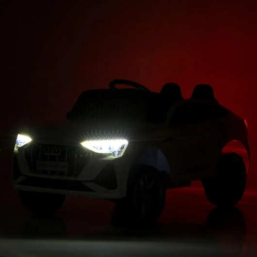 Светящиеся передние светодиодные фары детского электромобиля Audi в темноте